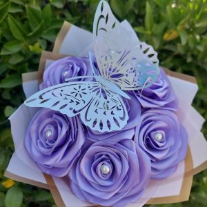 Ramo de 7 rosas eternas lilas, envuelto en papel coreano; un delicado arreglo floral de flores eternas.