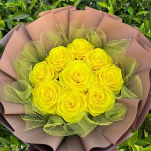 Ramo de 9 rosas eternas amarillas, envuelto en papel coreano café; un delicado arreglo floral de flores eternas.
