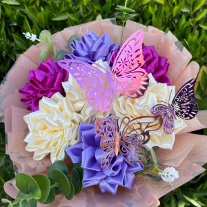 Ramo de 7 flores eternas de loto en tonos beige, lila y morado; un elegante arreglo floral con colores únicos.