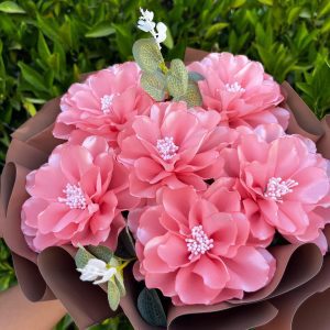 Ramo de 6 dalias eternas rosas, envueltas elegantemente en papel coreano color café; un hermoso arreglo floral de flores eternas.